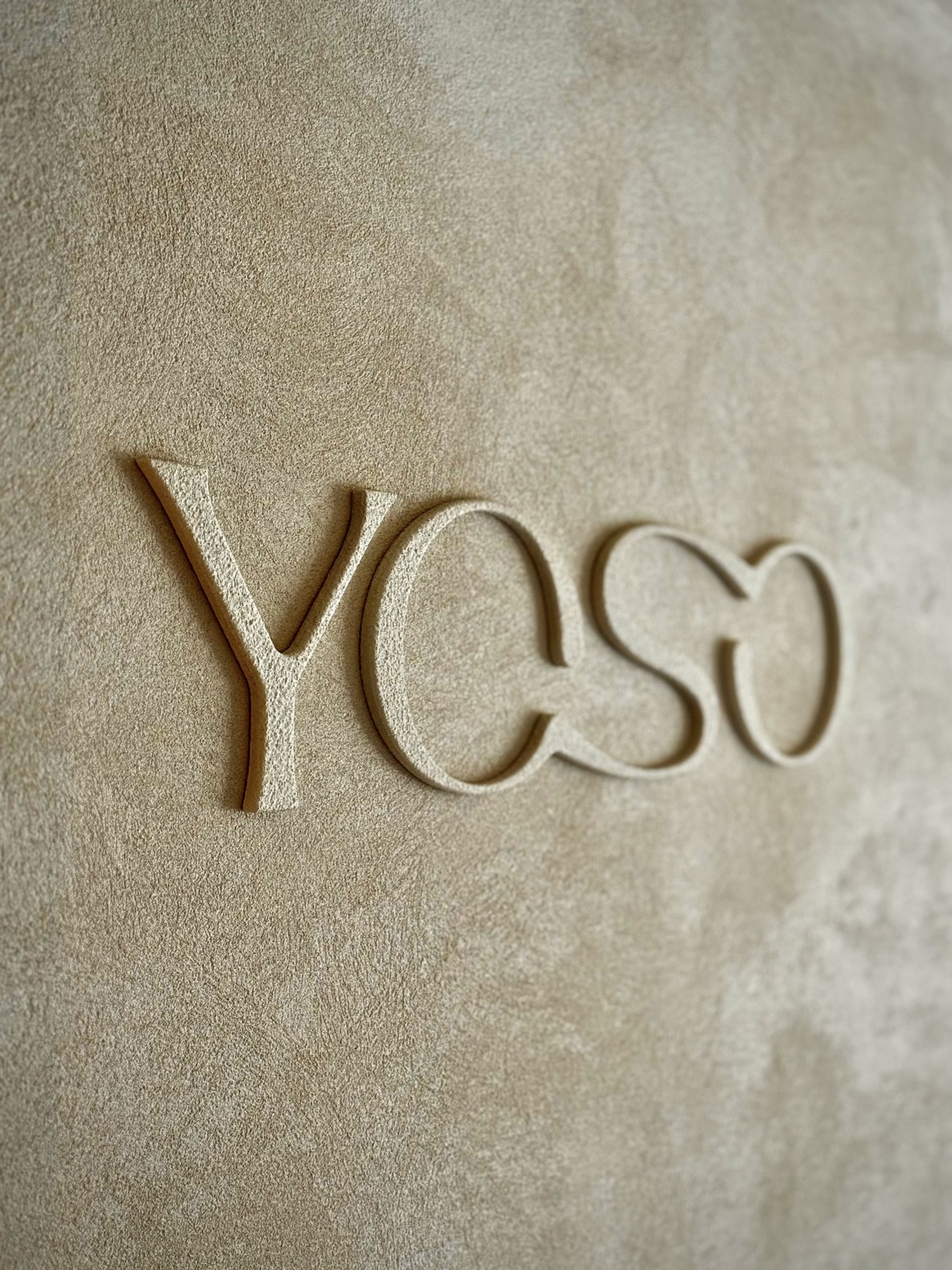 The YOSO logo set into a hand-finished clay wall