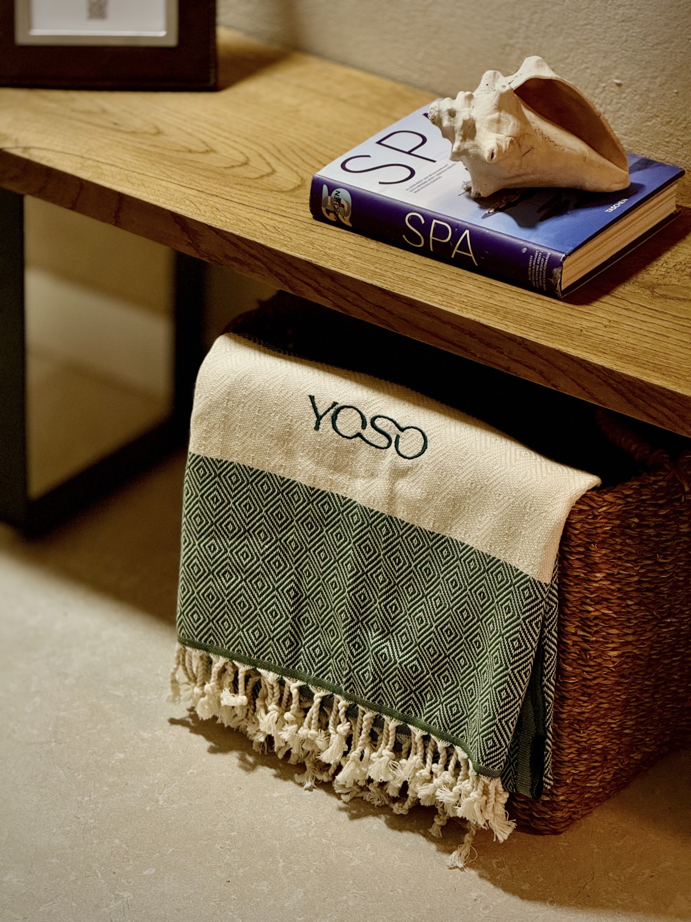 YOSO beach towel folded in a wicker basket