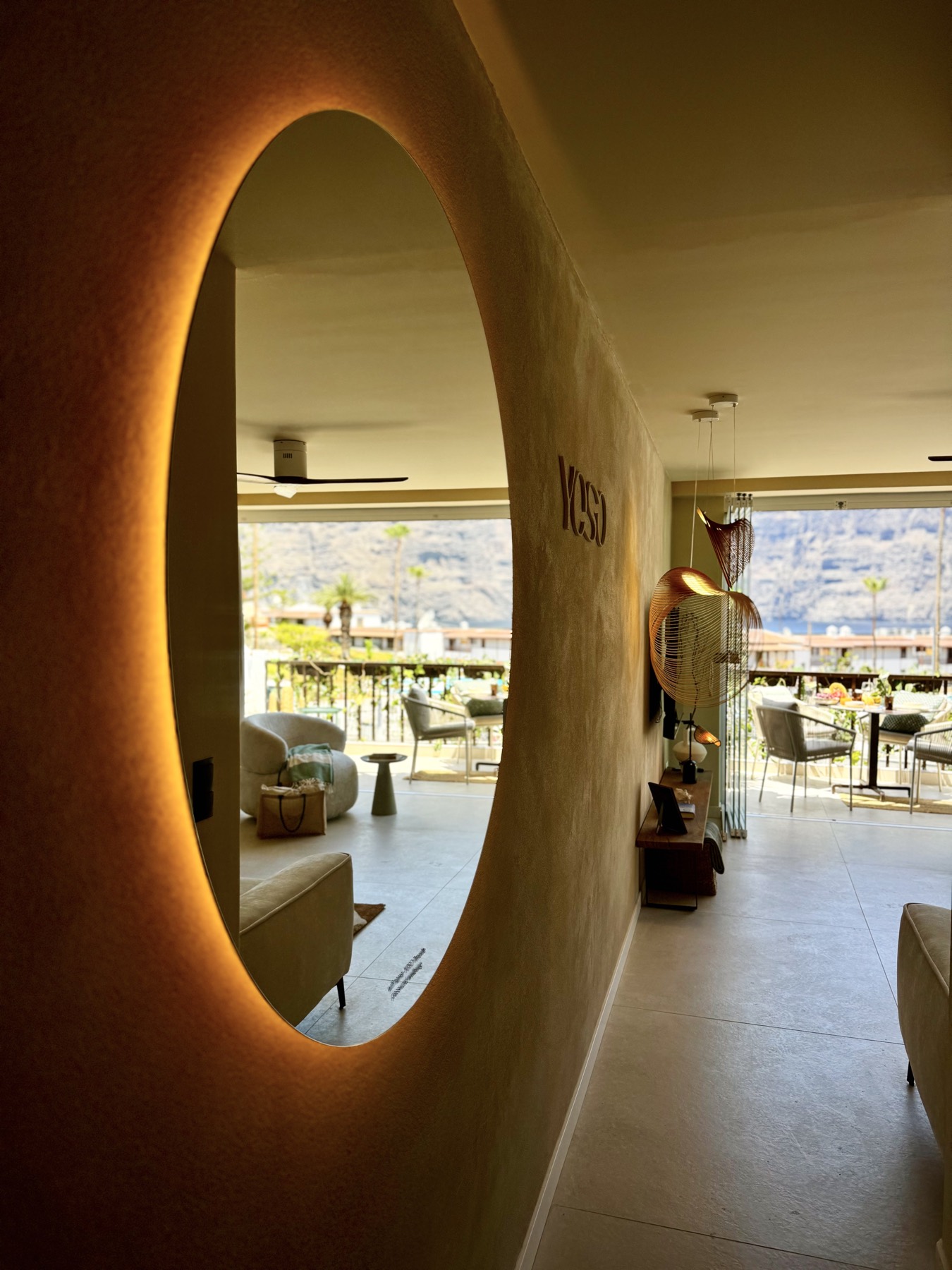 Backlit round mirror and the view beyond
